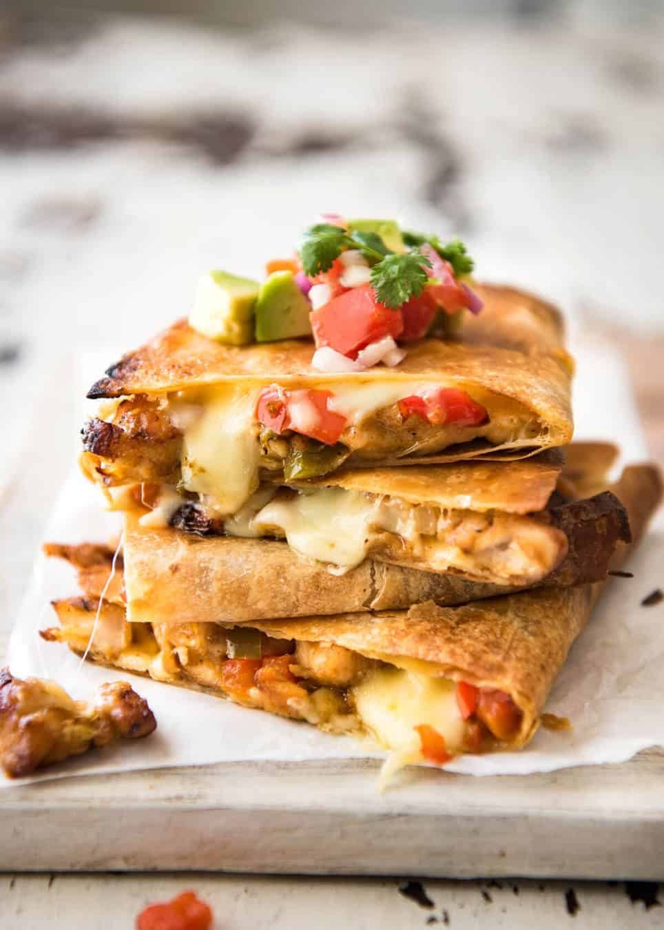 Crispy Oven Baked Chicken Quesadillas - This is how to make multiple Quesadillas at the same time! Crispy on the outside, stuffed with Mexican seasoned chicken and capsicum / bell peppers (and cheese of course!) www.recipetineats.com