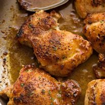 Close up of Crispy Garlic Chicken Thighs in a skillet with garlic butter sauce, fresh off the stove
