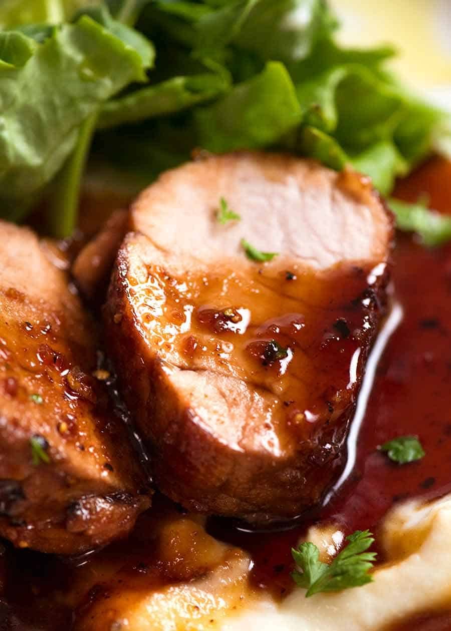Slice of juicy Honey Garlic Pork Tenderloin on a bed of creamy mashed cauliflower