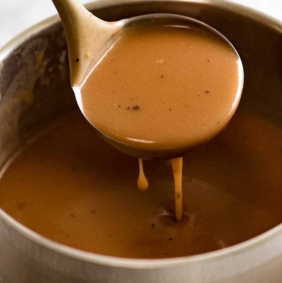 Ladling gravy out of saucepan, ready to pour over everything!